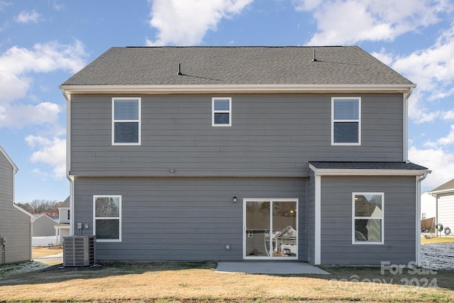 back of house featuring central air condition unit, a patio area, and a lawn