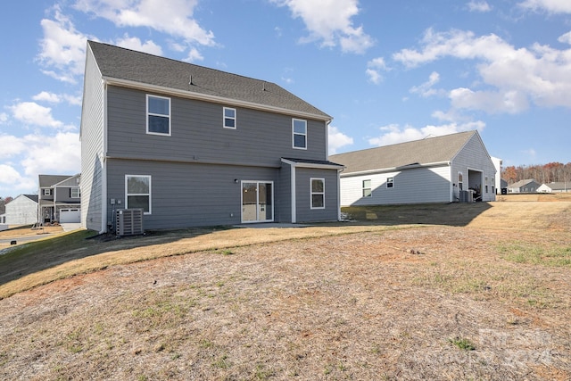 rear view of property featuring a lawn and central AC unit