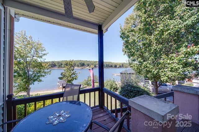 balcony with a water view and a ceiling fan