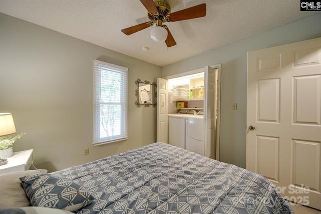 bedroom with a ceiling fan and washer and dryer