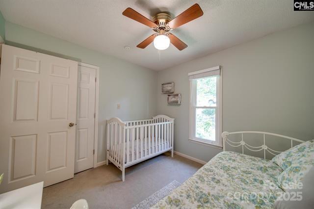 bedroom with ceiling fan, carpet flooring, and baseboards