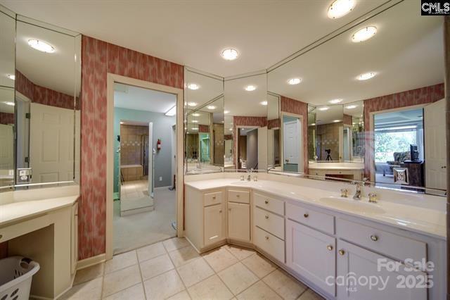 full bath with tile patterned flooring, double vanity, a sink, and wallpapered walls