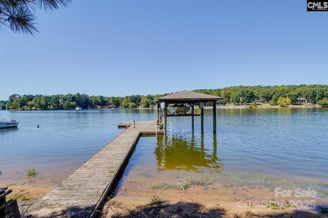 view of dock featuring a water view and a wooded view