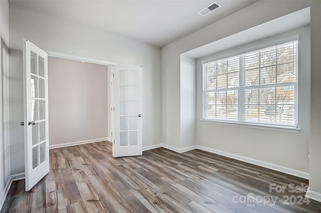 unfurnished room featuring french doors and wood-type flooring