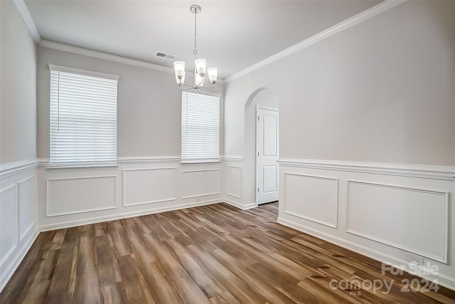 unfurnished dining area with hardwood / wood-style floors, a notable chandelier, and ornamental molding