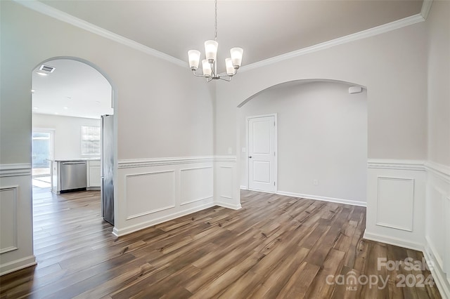 unfurnished dining area with hardwood / wood-style floors, ornamental molding, and an inviting chandelier