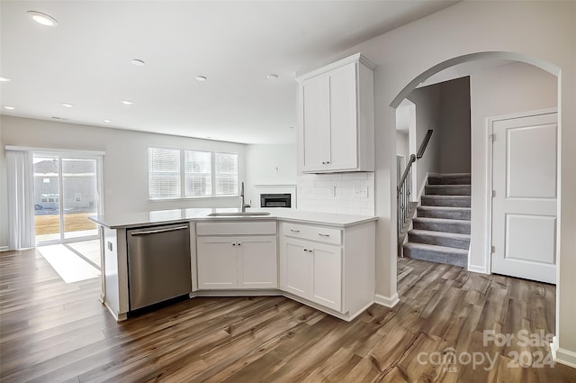 kitchen with white cabinets, dishwasher, sink, and hardwood / wood-style flooring