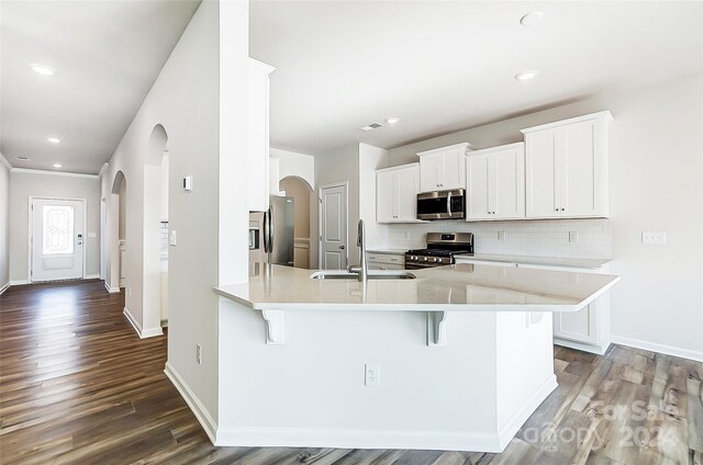 kitchen with a kitchen breakfast bar, sink, white cabinets, and appliances with stainless steel finishes