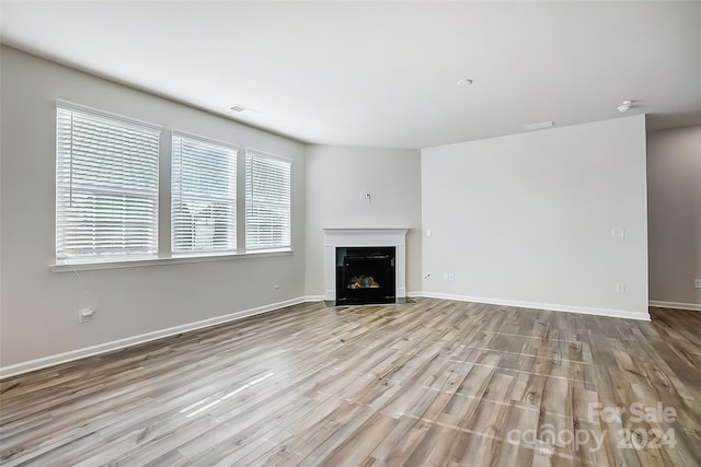 unfurnished living room featuring light hardwood / wood-style floors and a wealth of natural light