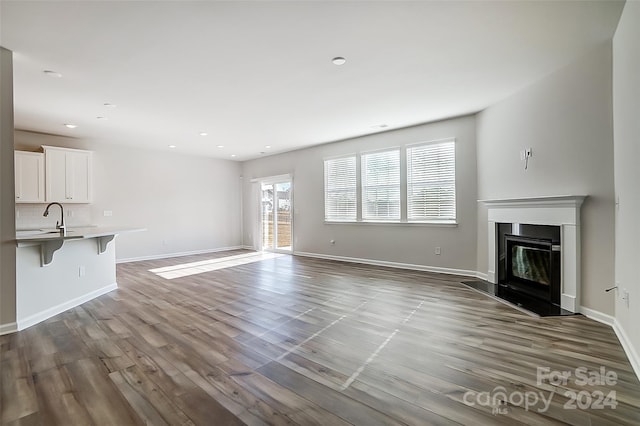 unfurnished living room featuring light hardwood / wood-style floors and sink