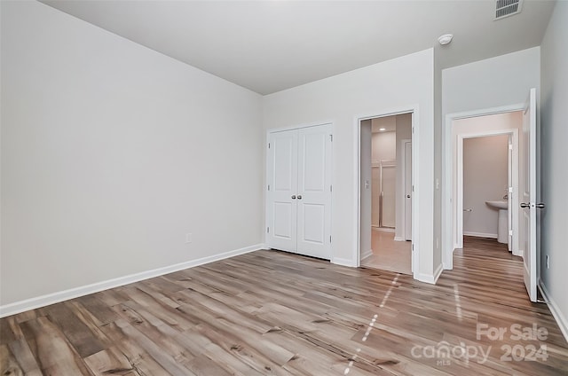 unfurnished bedroom with a closet and light hardwood / wood-style flooring