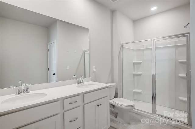 bathroom with tile patterned flooring, vanity, toilet, and an enclosed shower