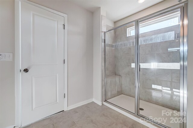 bathroom featuring tile patterned flooring and an enclosed shower