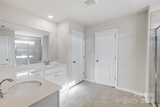 bathroom featuring tile patterned flooring, vanity, and walk in shower