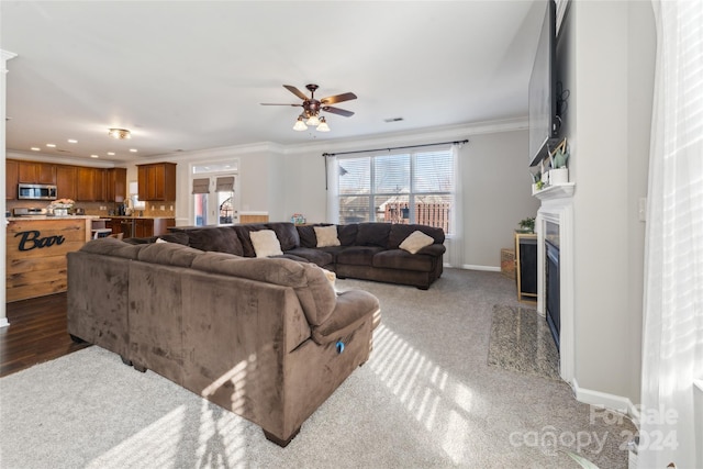 living room featuring crown molding, ceiling fan, and wood-type flooring