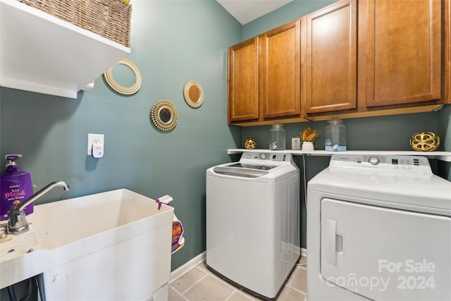 washroom featuring cabinets, independent washer and dryer, and sink