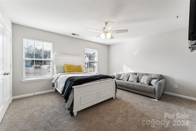 bedroom with multiple windows, ceiling fan, and carpet floors