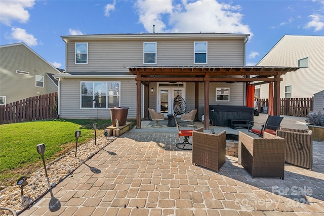 rear view of house with a lawn, an outdoor living space, a patio, and a hot tub