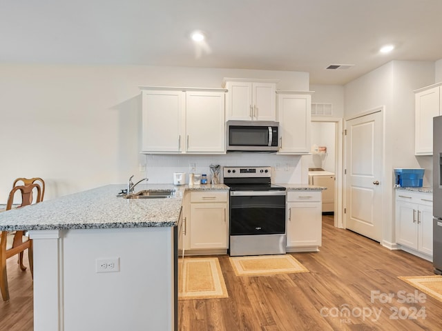 kitchen featuring sink, tasteful backsplash, light hardwood / wood-style floors, white cabinetry, and stainless steel appliances