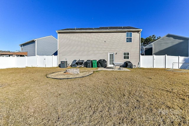 back of house featuring a lawn, cooling unit, and a patio area