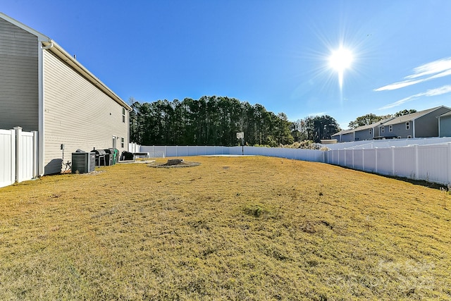 view of yard with central air condition unit and an outdoor fire pit