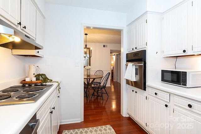 kitchen with dark wood-type flooring, white cabinetry, and appliances with stainless steel finishes