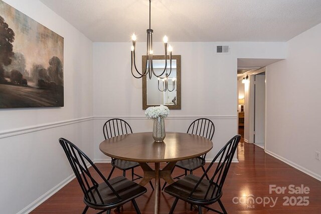 dining room featuring dark hardwood / wood-style flooring and a notable chandelier