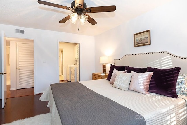 bedroom featuring ceiling fan, independent washer and dryer, connected bathroom, and hardwood / wood-style floors