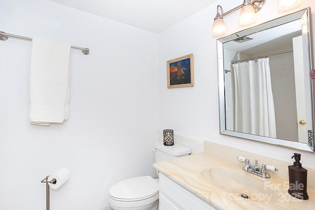 bathroom featuring toilet, a shower with shower curtain, and vanity