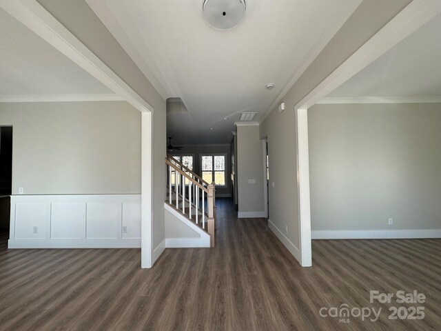 interior space with ornamental molding, stairway, dark wood finished floors, and visible vents