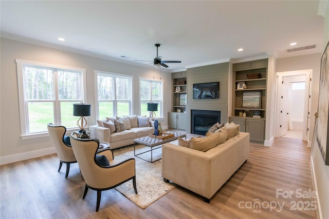 1875 Rock Hill Church Rd Unit 4, Matthews, NC 28104 - living area featuring a fireplace, light wood finished floors, built in features, ceiling fan, and crown molding