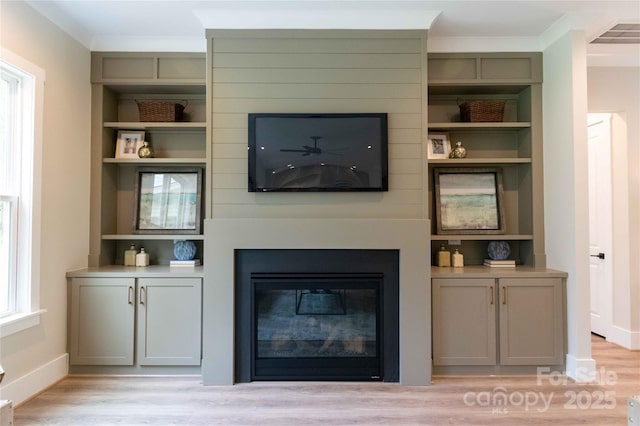 1875 Rock Hill Church Rd Unit 4, Matthews, NC 28104 - living room with a glass covered fireplace, light wood finished floors, and built in shelves