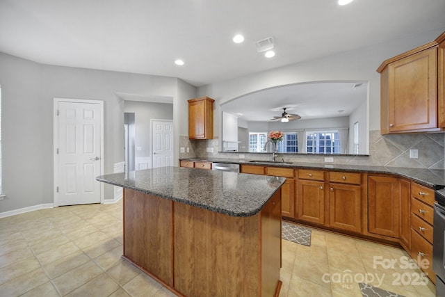 kitchen featuring sink, stainless steel dishwasher, ceiling fan, light tile patterned floors, and tasteful backsplash