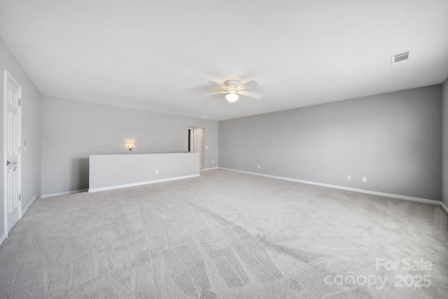 empty room with ceiling fan and light carpet