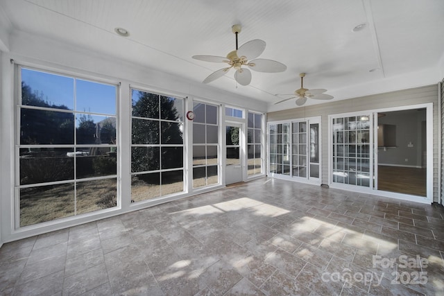 unfurnished sunroom featuring ceiling fan