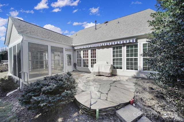 rear view of property featuring a sunroom and a patio area