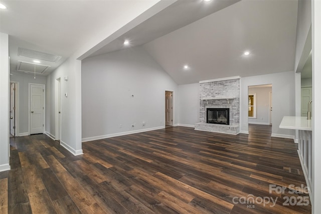 unfurnished living room featuring a fireplace, dark wood-type flooring, and high vaulted ceiling