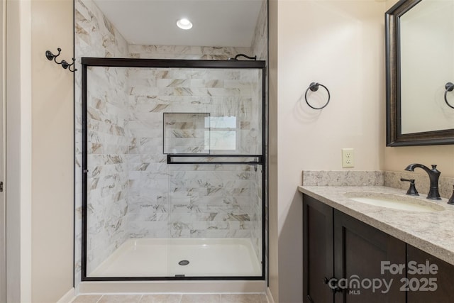 bathroom with a shower with door and vanity