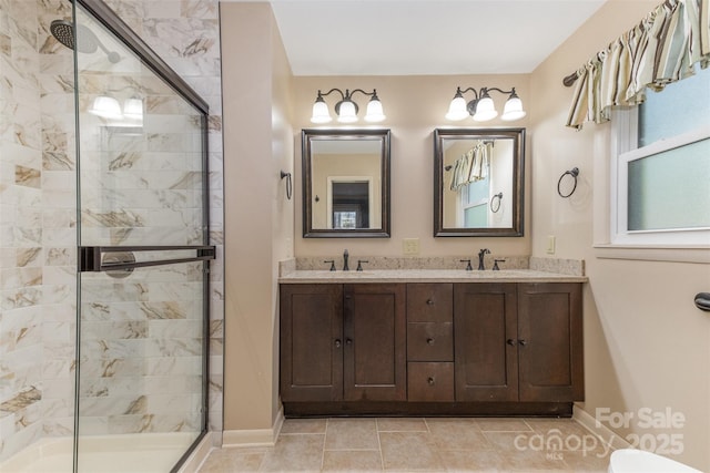 bathroom with a shower with shower door, vanity, and tile patterned flooring