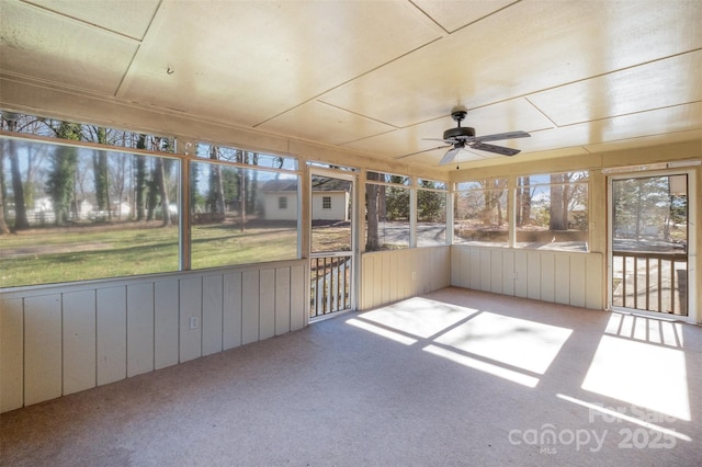 unfurnished sunroom with ceiling fan