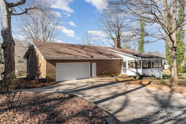 ranch-style home featuring a sunroom and a garage