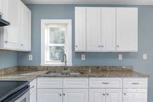 kitchen featuring dark stone counters, white cabinets, a sink, and ventilation hood