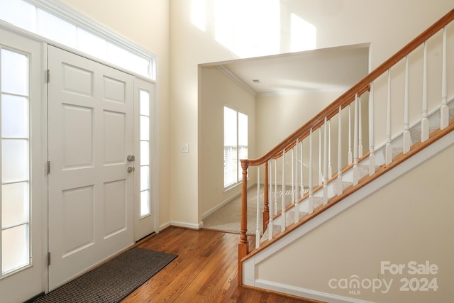 entryway with crown molding and light hardwood / wood-style floors