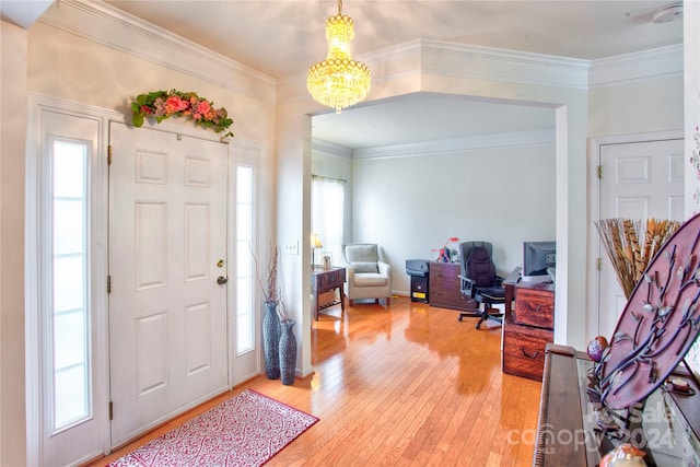 foyer entrance featuring hardwood / wood-style floors, crown molding, and a notable chandelier