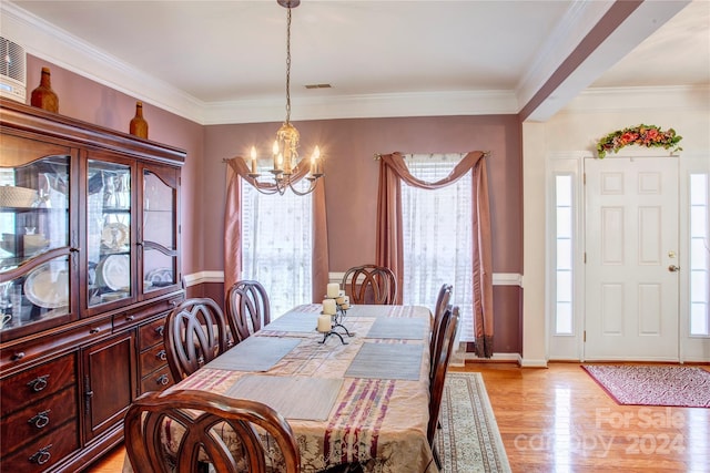 dining space featuring a wealth of natural light, ornamental molding, a notable chandelier, and light wood-type flooring