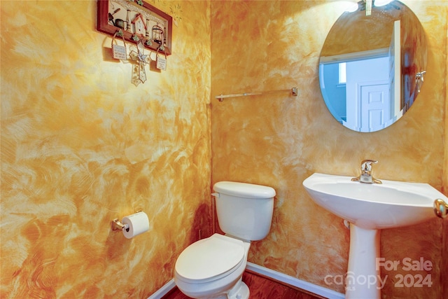 bathroom featuring wood-type flooring, toilet, and sink