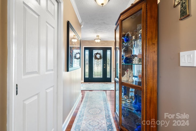 doorway with a textured ceiling and dark hardwood / wood-style floors