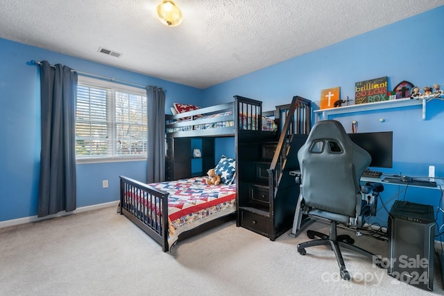 bedroom with a textured ceiling and carpet floors