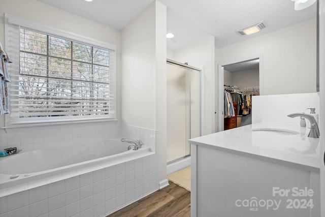 bathroom featuring separate shower and tub, hardwood / wood-style floors, and vanity