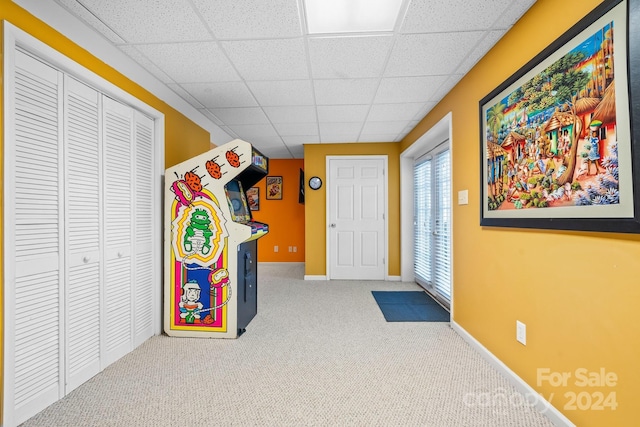 recreation room featuring carpet and a drop ceiling